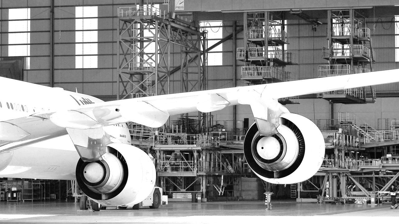 Aircraft in a hangar undergoing maintenance, illustrating the integration of Lean practices for optimizing Aircraft Maintenance Programs and ensuring airworthiness.